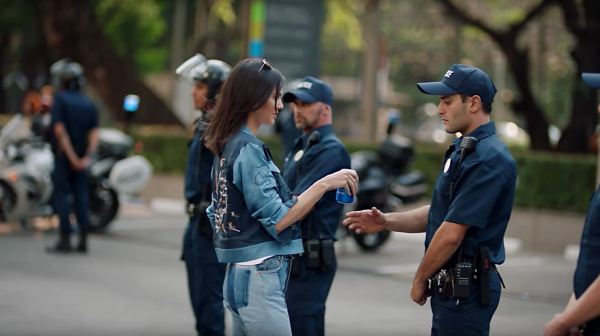 Kendall Jenner gives Pepsi to police officer