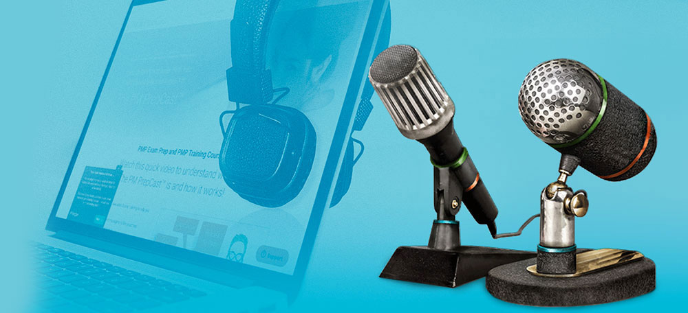 Two microphones next to earphones and a laptop that shows the PMP Prepcast website